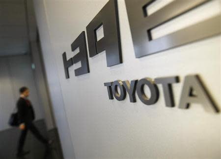 A man is seen next to a Toyota Motor Corp's signboard as he enters its office in Nagoya, central Japan February 2, 2010. REUTERS/Kim Kyung-Hoon