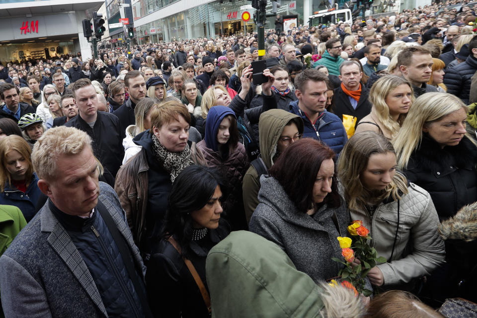 People observe a minute of silence near the department store Ahlens in Stockholm, Sweden, Monday, April 10, 2017, to honor the four killed victims and 15 injured in a fatal truck attack. The attack was allegedly carried out by an asylum-seeker from Uzbekistan who drove the stolen vehicle into a crowd of shoppers on a busy Friday afternoon in downtown Stockholm. (AP Photo/Markus Schreiber)