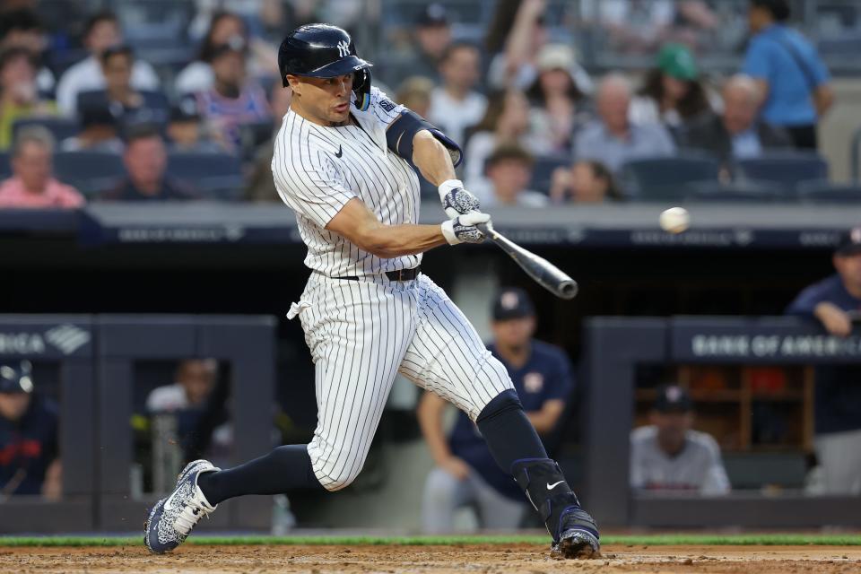 New York Yankees designated hitter Giancarlo Stanton (27) hits a solo home run against the Houston Astros during the third inning at Yankee Stadium.