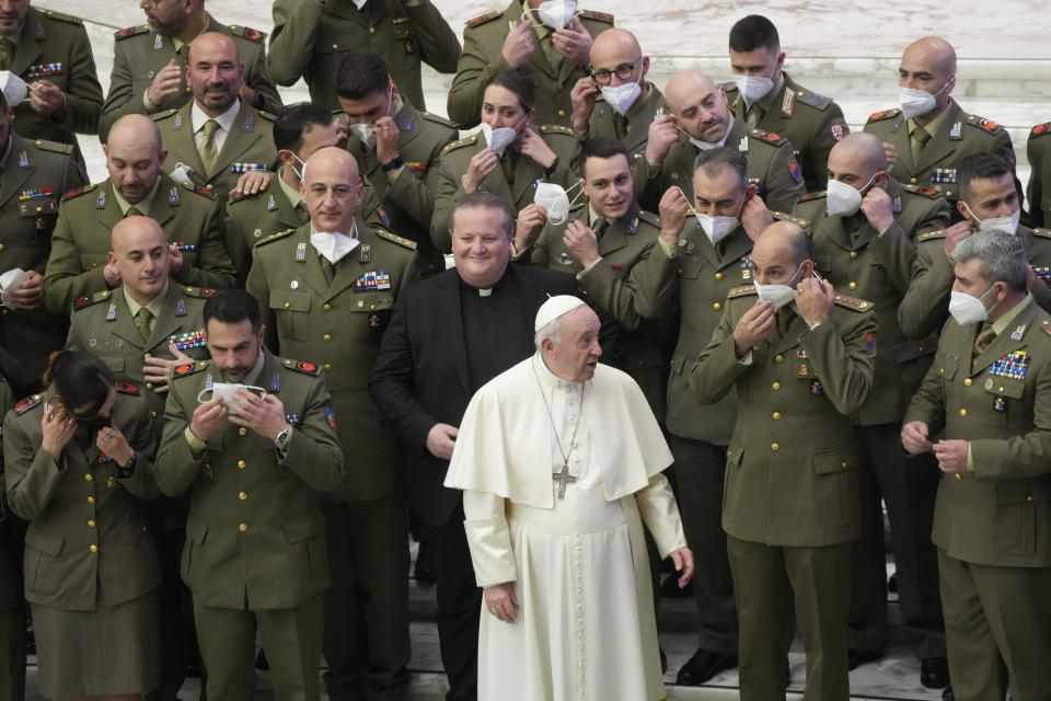 Pope Francis asks Italian Army officers to remove their face masks to take a family picture during the weekly general audience at the Vatican, Wednesday, March 2, 2022. (AP Photo/Gregorio Borgia)