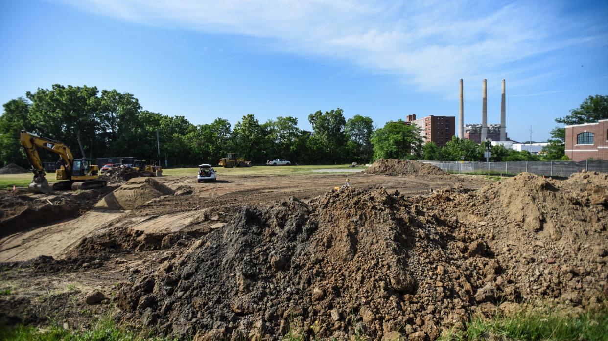Workers move dirt at the corner of West Malcolm X Street and South Washington Avenue Wednesday, July 15, 2022.