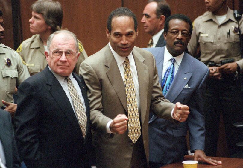 FILE - In this Oct. 3, 1995, file photo, O.J. Simpson reacts as he is found not guilty in the death of his ex-wife Nicole Brown Simpson and her friend Ron Goldman in Los Angeles. Defense attorneys F. Lee Bailey, left, and Johnnie L. Cochran Jr. stand with him. Cochran, Simpson's flamboyant lead attorney, died of brain cancer in 2005 at 68. His refrain to jurors that "If it doesn't fit, you must acquit" sought to underscore that the bloody gloves found at Simpson's home and the crime scene were too small for football legend when he tried them on in court. (Myung J. Chun/Los Angeles Daily News via AP, Pool, File)