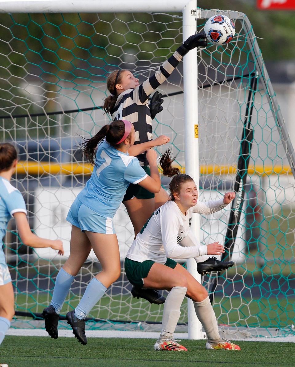 Williamston goalkeeper Abby Pieper, center, deflects a shot against Garber's Joann Brissette, left, as Williamston's Ashley Stover also defends, Friday, June 11, 2021, in Freeland, Mich.