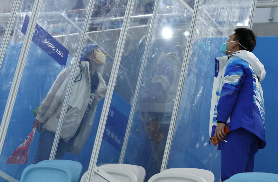 2022 Beijing Olympics - Speed Skating - Men's 5000m - National Speed Skating Oval, Beijing, China - February 6, 2022.  Dr. Ding Hongtao, part of the medical staff, blows a kiss to his girlfriend through screens of glass that separate them because of the 