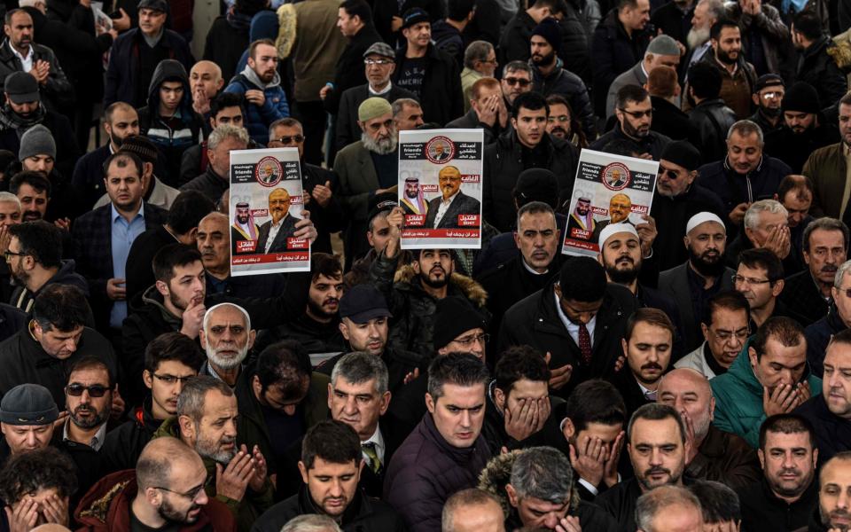 People hold banners of Jamal Khashoggi during a symbolic funeral prayer for the Saudi journalist, killed and dismembered in the Saudi consulate in Istanbul in October - AFP