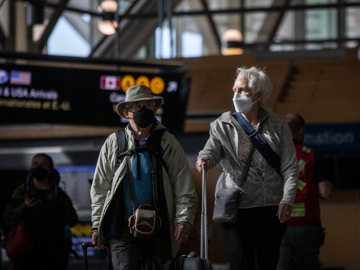 Travellers at Vancouver International Airport in Richmond, British Columbia. B.C. health officials say they're expecting a surge in COVID-19 and flu cases through the fall and winter seasons. (Ben Nelms/CBC - image credit)