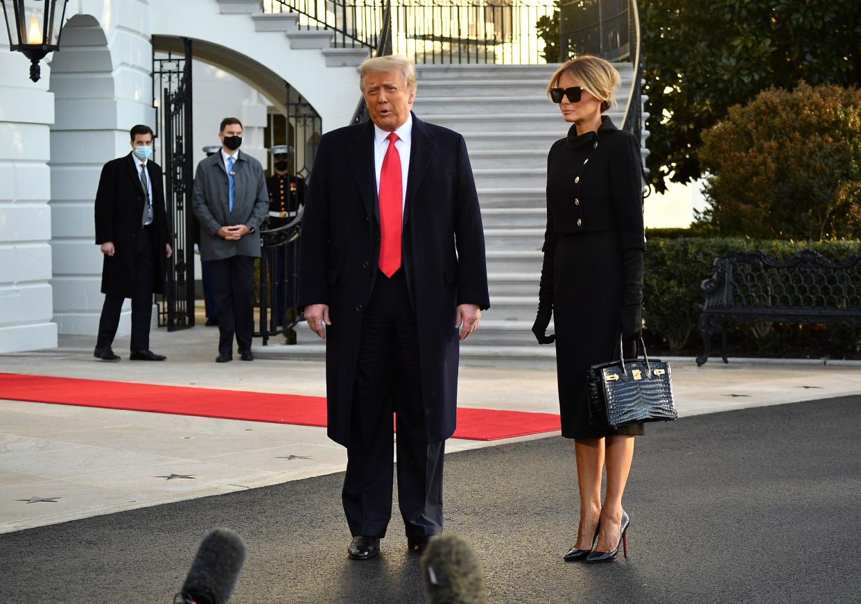 Outgoing US President Donald Trump and First Lady Melania Trump talk to the press as they depart the White House in Washington, DC, on January 20, 2021. - President Trump travels to his Mar-a-Lago golf club residence in Palm Beach, Florida, and will not attend the inauguration for President-elect Joe Biden. (Photo by MANDEL NGAN / AFP) (Photo by MANDEL NGAN/AFP via Getty Images)