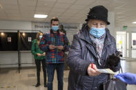 Lithuanian's, wearing face masks to protect against coronavirus, queue to cast their ballots at a polling station during the second round of a parliamentary election in Vilnius, Lithuania, Sunday, Oct. 25, 2020. Polls opened Sunday for the run-off of national election in Lithuania, where the vote is expected to bring about a change of government following the first round, held on Oct. 11, which gave the three opposition, center-right parties a combined lead. (AP Photo/Mindaugas Kulbis)