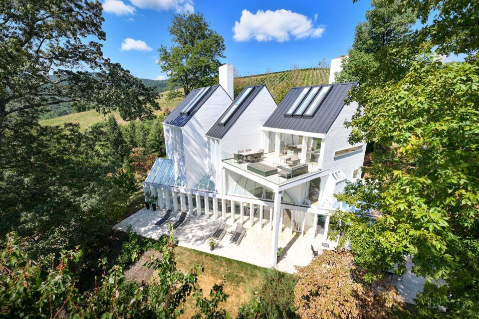 Designed by Hugh Newell Jacobsen, the triple-gabled residence has vaulted ceilings, huge skylights, and a glass-encased indoor pool.