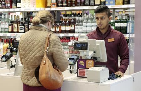 An employee works at a till in a Sainsbury's Local store in central London, Britain October 23, 2015. REUTERS/Suzanne Plunkett