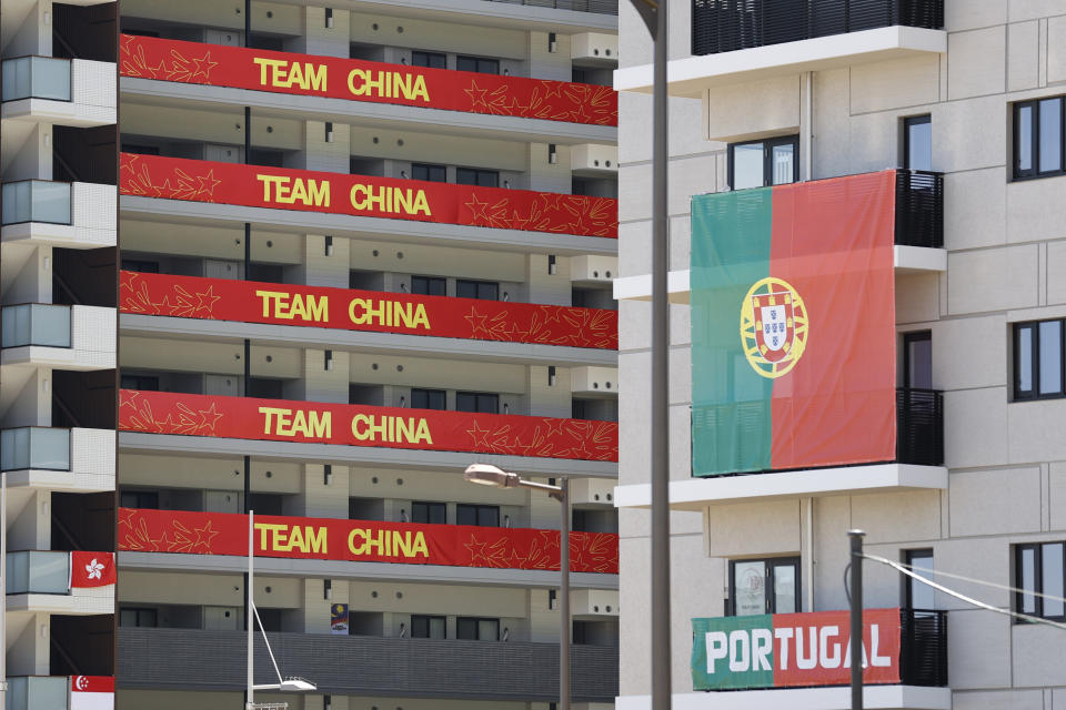 Flags of Team China and Portugal hanging on residential buildings in the athletes' village for the Tokyo Olympics.