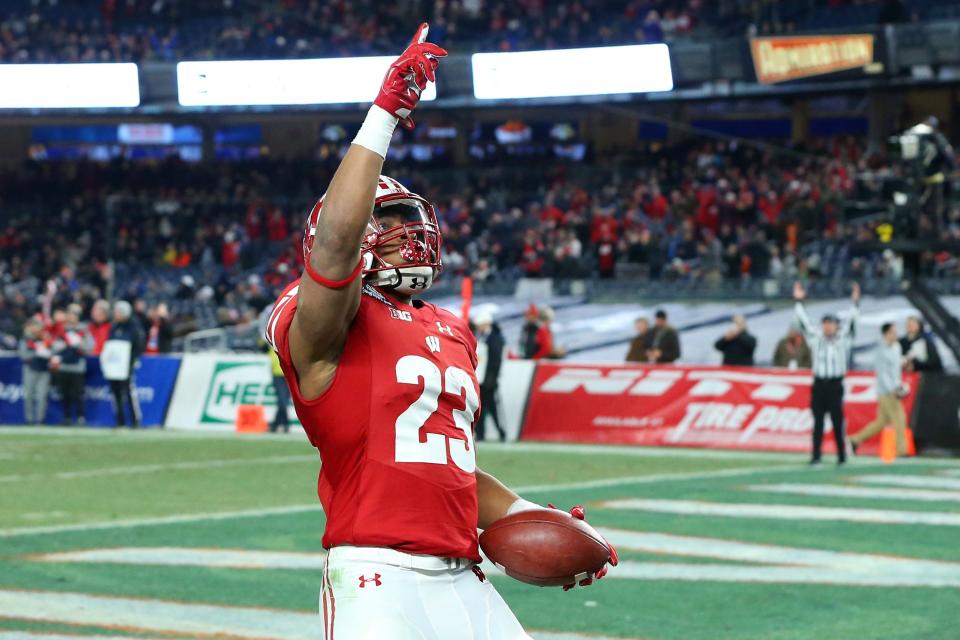 Jonathan Taylor (23) gestures following his touchdown run against the Miami Hurricanes during the first quarter of the Wisconsin Badgers' game against the Miami Hurricanes in the 2018 Pinstripe Bowl at Yankee Stadium.