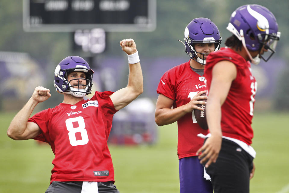 Minnesota Vikings quarterback Kirk Cousins (8) responds to the crowd, next to quarterbacks Nate Stanley (14) and Kellen Mond (11) during NFL football training camp Friday, July 30, 2021, in Eagan, Minn. (AP Photo/Bruce Kluckhohn)