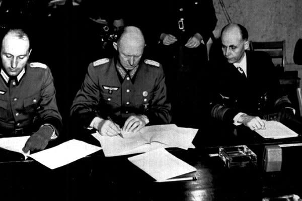 Germany's Gen. Gustav Jodl (C) signs the unconditional surrender documents on May 7, 1945, in Reims, France, ending the war in Europe. He is flanked by Col. Wilhelm Oxenius (L), his aide, and German Adm. Hans Georg von Friedeburg. UPI File Photo