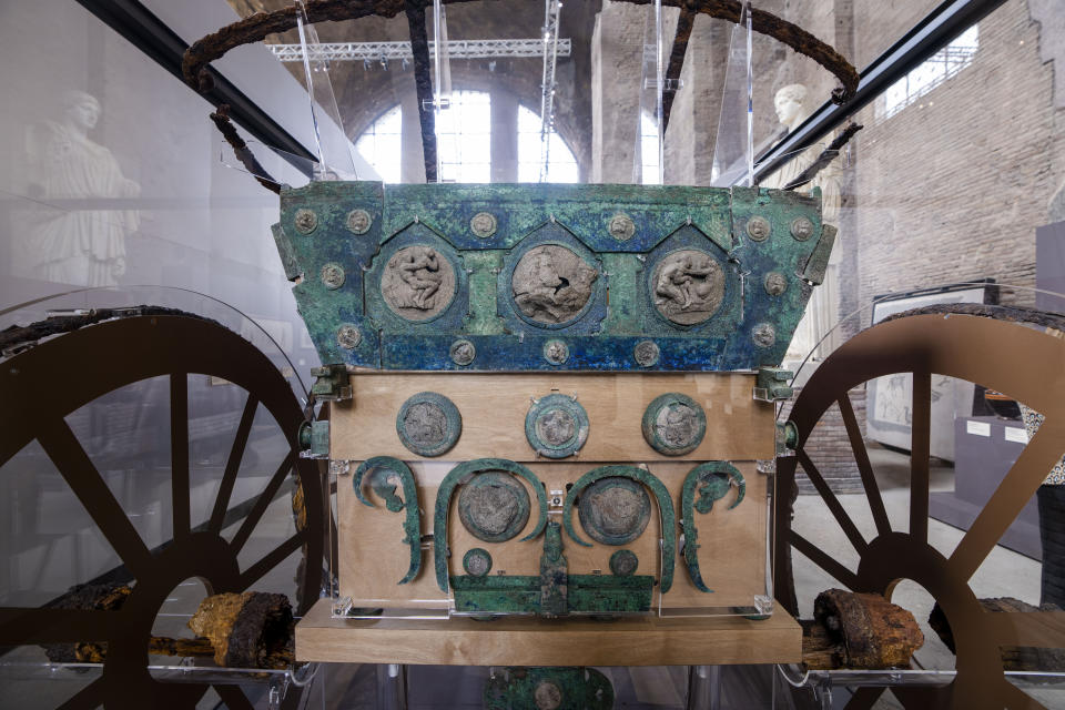 A reconstructed Pompeii bridal chariot, found in 2021 under 4 meters (15 feet) of volcanic ash is on display at the exhibition 'Between us and the ancients. The instant and eternity' in Rome's Diocletian Baths, Wednesday, May 3, 2023. The four-wheeled chariot features silver and bronze decorations, including of erotic scenes. The exhibition will open to the public from May 4 through July 30, 2023. (AP Photo/Domenico Stinellis)