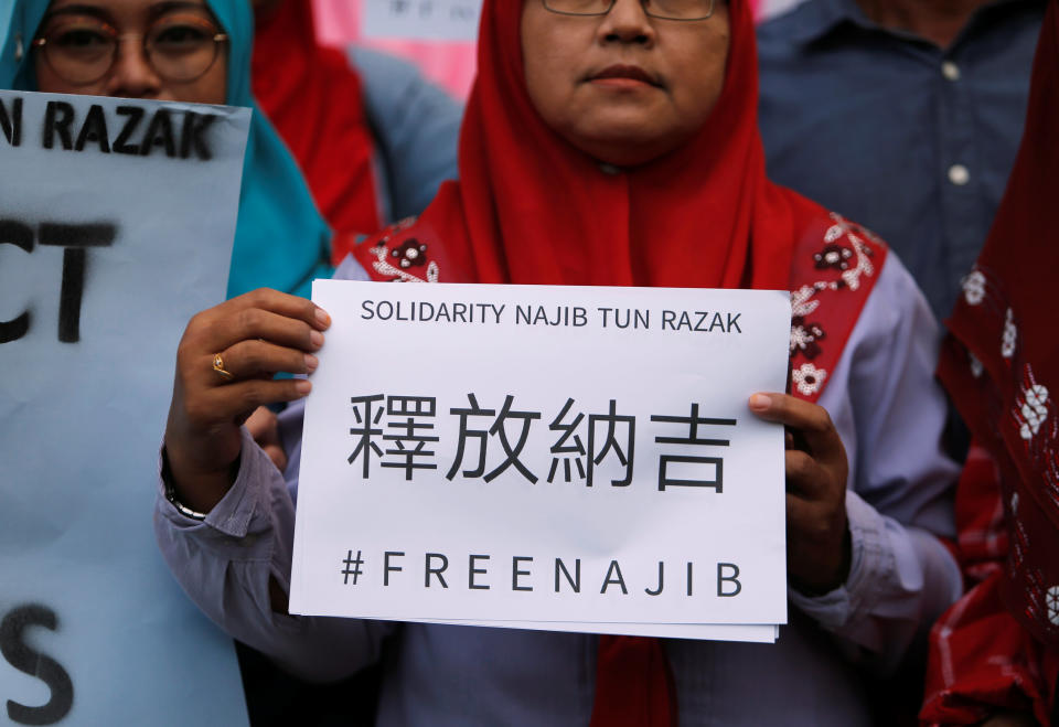 <p>A supporter of former Malaysian prime minister Najib Razak holds up a sign, ahead of his arrival to court at the Kuala Lumpur Courts Complex on Wednesday (4 July) morning. (PHOTO: Reuters) </p>