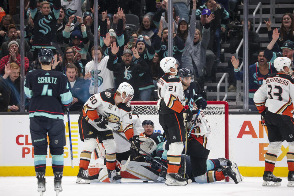 Seattle Kraken center Jaden Schwartz (17) and fans celebrate a goal, while Anaheim Ducks defenseman Jackson LaCombe (60) and center Isac Lundestrom (21) skate off during the second period of an NHL hockey game Thursday, March 28, 2024, in Seattle. (AP Photo/Jason Redmond)