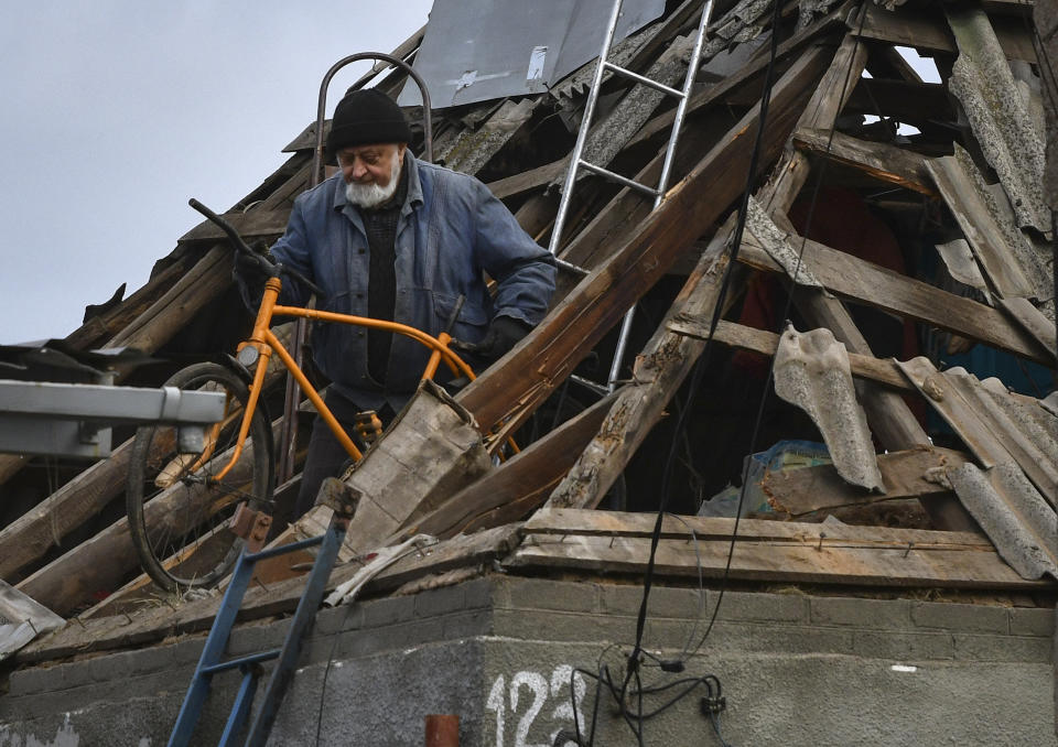 A local resident moves a bicycle from the attic of damaged house after Russian shelling in Kramatorsk, Ukraine, Thursday, Nov. 10, 2022. (AP Photo/Andriy Andriyenko)