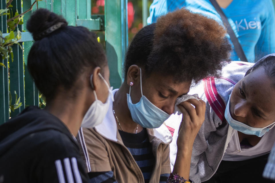 An Ethiopian domestic worker cries as she waits with dozens of others outside the Ethiopian consulate, some inquiring about flights home, others stranded after they were abandoned by employers who claimed they could no longer afford to pay their salaries, in Hazmieh, east of Beirut, Lebanon, Thursday, June 4, 2020. Some 180,000 domestic workers in Lebanon, most of them female from Ethiopia, are growing more desperate as a crippling economic and financial crisis sets in, coupled with coronavirus restrictions. (AP Photo/Hassan Ammar)