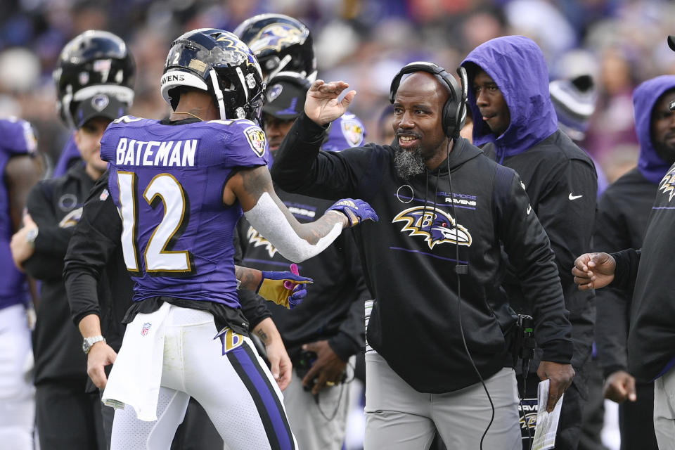 Baltimore Ravens wide receiver Rashod Bateman (12) is congratulated by pass game specialist coach Keith Williams during the second half of an NFL football game against the Los Angeles Chargers, Sunday, Oct. 17, 2021, in Baltimore. (AP Photo/Nick Wass)