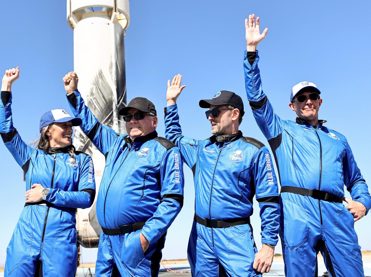 Blue Origins vice president of mission and flight operations Audrey Powers, Star Trek actor William Shatner, Planet Labs co-founder Chris Boshuizen and Medidata Solutions co-founder Glen de Vries wave during a media availability on the landing pad of Blue Origin’s New Shepard after they flew into space on October 13, 2021 near Van Horn, Texas.