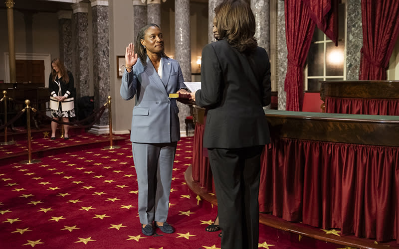 Sen. Laphonza Butler (D-Calif.) is standing on the left. She has her right hand raised as she swears in. On the right, facing her, is Vice President Harris.