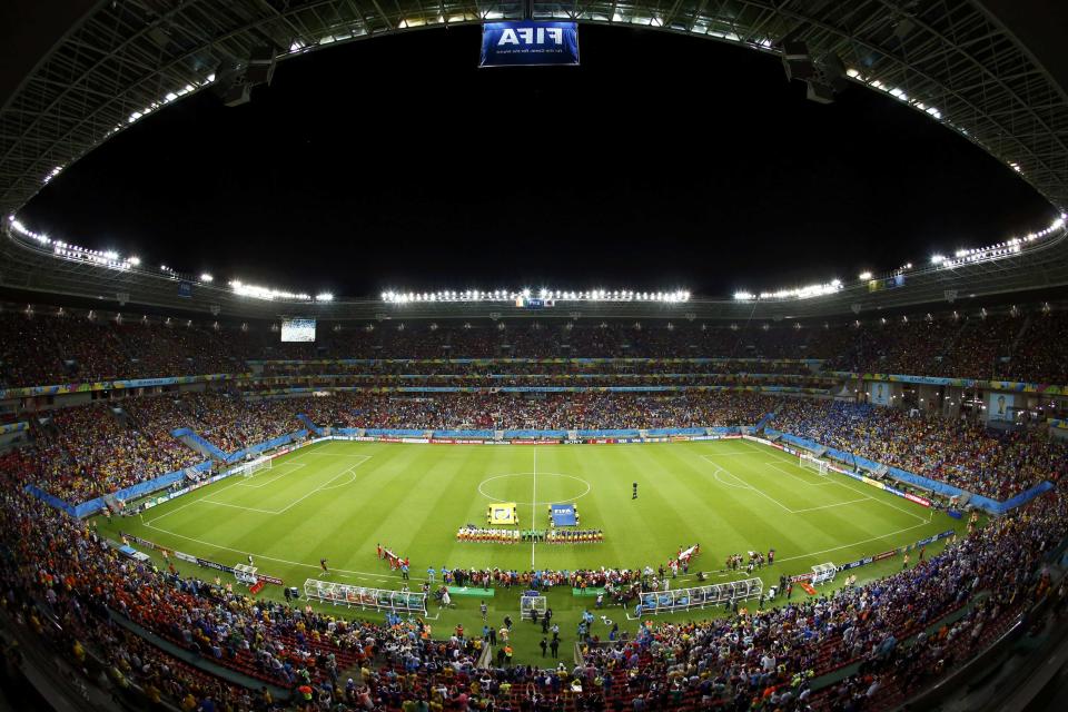 Ivory Coast and Japan players gather on the pitch before their 2014 World Cup Group C soccer match at the Pernambuco arena in Recife June 14, 2014. Picture taken with wide angle lens. REUTERS/Ruben Sprich