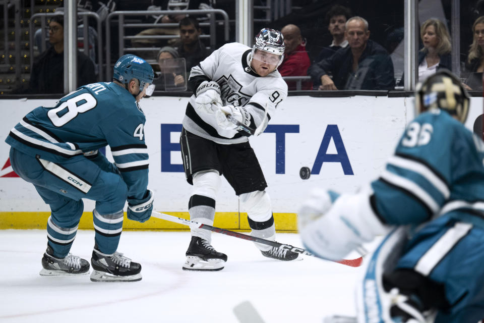 Los Angeles Kings right wing Carl Grundstrom (91) shoots past San Jose Sharks center Tomas Hertl (48) during the second period of an NHL hockey game Wednesday, Dec. 27, 2023, in Los Angeles. (AP Photo/Kyusung Gong)