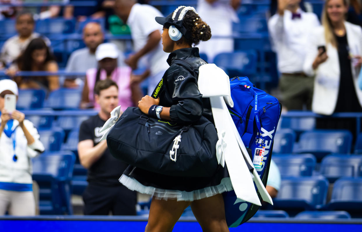 Naomi Osaka of Japan walks on court in a black-and-white outfit with a showstopper bow on Aug. 29. 