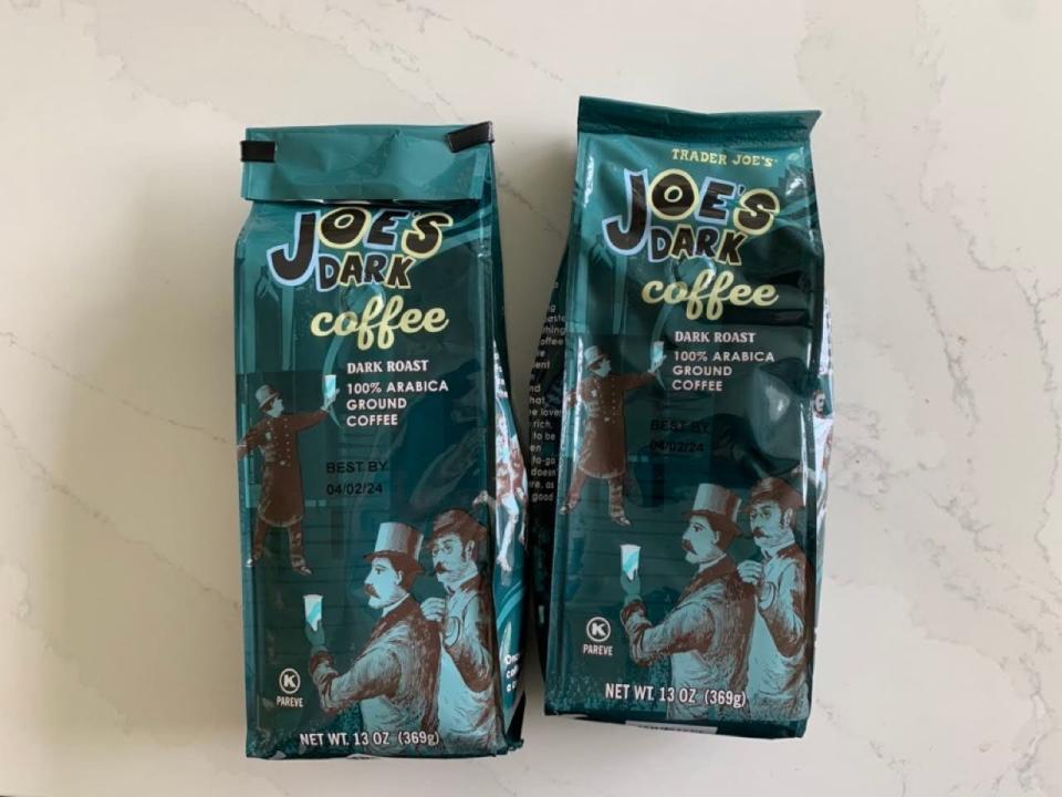 Two bags of Trader Joe's dark-roast coffee on a marble countertop.