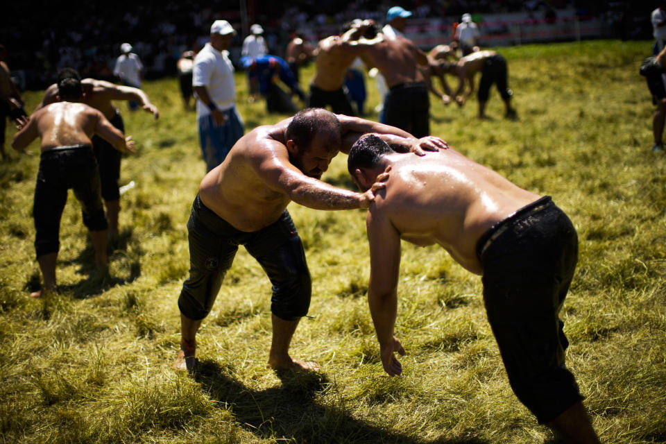 Wrestlers compete during the 661st annual Historic Kirkpinar Oil Wrestling championship, in Edirne, northwestern Turkey, Saturday, July 2, 2022. The festival is part of UNESCO's List of Intangible Cultural Heritages. (AP Photo/Francisco Seco)