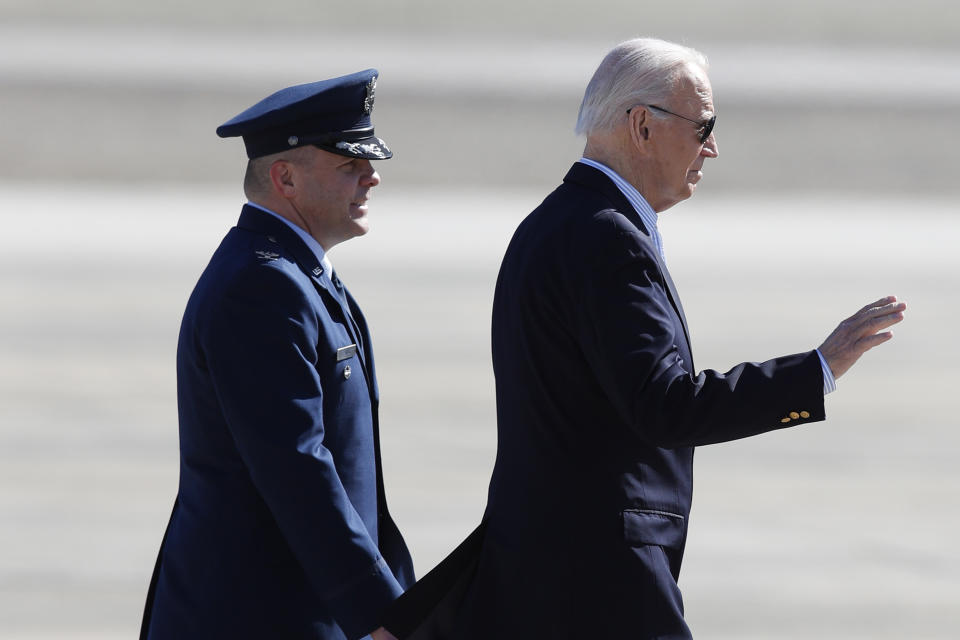 President Joe Biden, escorted by Col. Paul Pawluk, Vice Commander, 89th Airlift Wing, waves before boarding Air Force One, Thursday, Feb. 29, 2024, at Andrews Air Force Base, Md, en route to visit the U.S.- Mexico border in Brownsville, Texas. (AP Photo/Luis M. Alvarez)