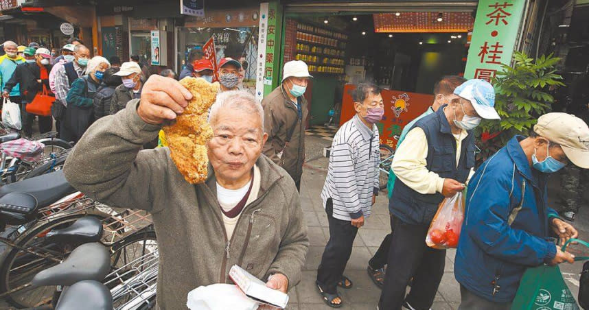 本名廖榮吉的「刈包吉」（前）4日在台北市艋舺公園發送500個便當、500份雞排與1000個饅頭給需要的民眾。（圖／中國時報劉宗龍攝）