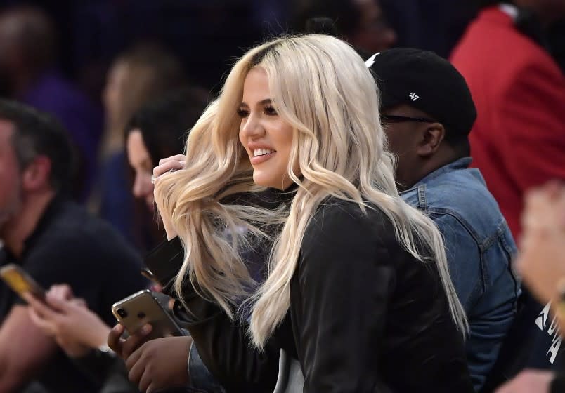 FILE - In this Jan. 13, 2019, file photo, Khloe Kardashian watches during the second half of an NBA basketball game between the Los Angeles Lakers and the Cleveland Cavaliers in Los Angeles. Kardashian says she had tested positive for the coronavirus. The reality star confirmed her previous diagnosis in a Wednesday, Oct. 28, 2020, sneak peek clip of "Keeping Up with the Kardashians." The bedridden Kardashian spoke in the video with a hoarse voice. (AP Photo/Mark J. Terrill, File)