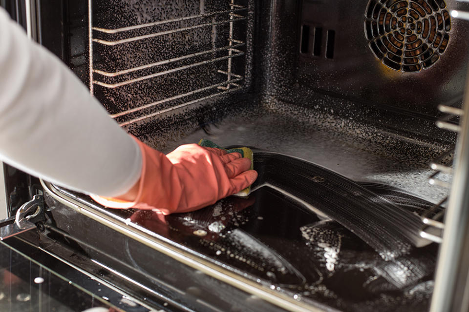 Woman cleaning oven