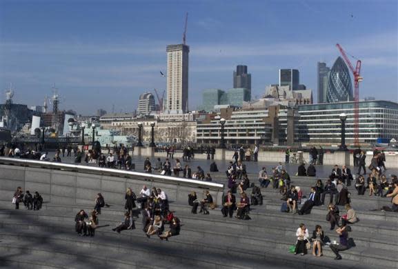 People eat their lunch along the south bank in London March 12, 2012.