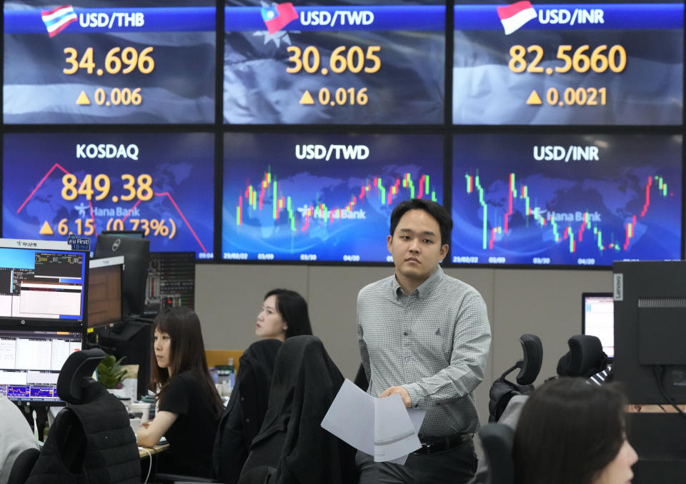 A currency trader passes by the screens showing the foreign exchange rates at the foreign exchange dealing room of the KEB Hana Bank headquarters in Seoul, South Korea, Tuesday, May 30, 2023. Asian shares were mixed in directionless trading Tuesday following a U.S. holiday, as optimism about a deal on the U.S. debt mixed with worries about the regional economy. (AP Photo/Ahn Young-joon)