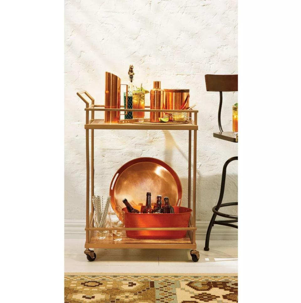 Get <strong><a href="https://fave.co/2MJrCv0" target="_blank" rel="noopener noreferrer">this wood and glass gold-finished rolling bar cart for 25% off</a></strong>&nbsp;at Target today only. (Photo: Target)