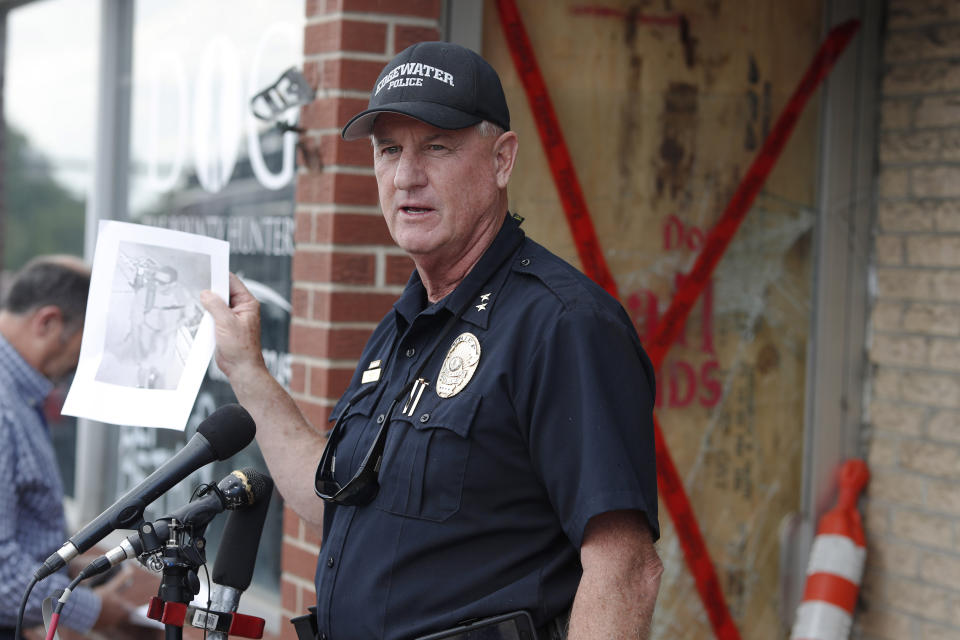 Edgewater, Colo., Police Chief John Mackey holds up an image of the suspect in the break-in of the storefront owned by Duane "Dog the Bounty Hunter" Chapman during a news conference Friday, Aug. 2, 2019, in Edgewater, Colo. Police in Colorado said Friday they are investigating a reported burglary of a business owned by "Dog the Bounty Hunter" reality TV star Duane "Dog" Chapman. (AP Photo/David Zalubowski)