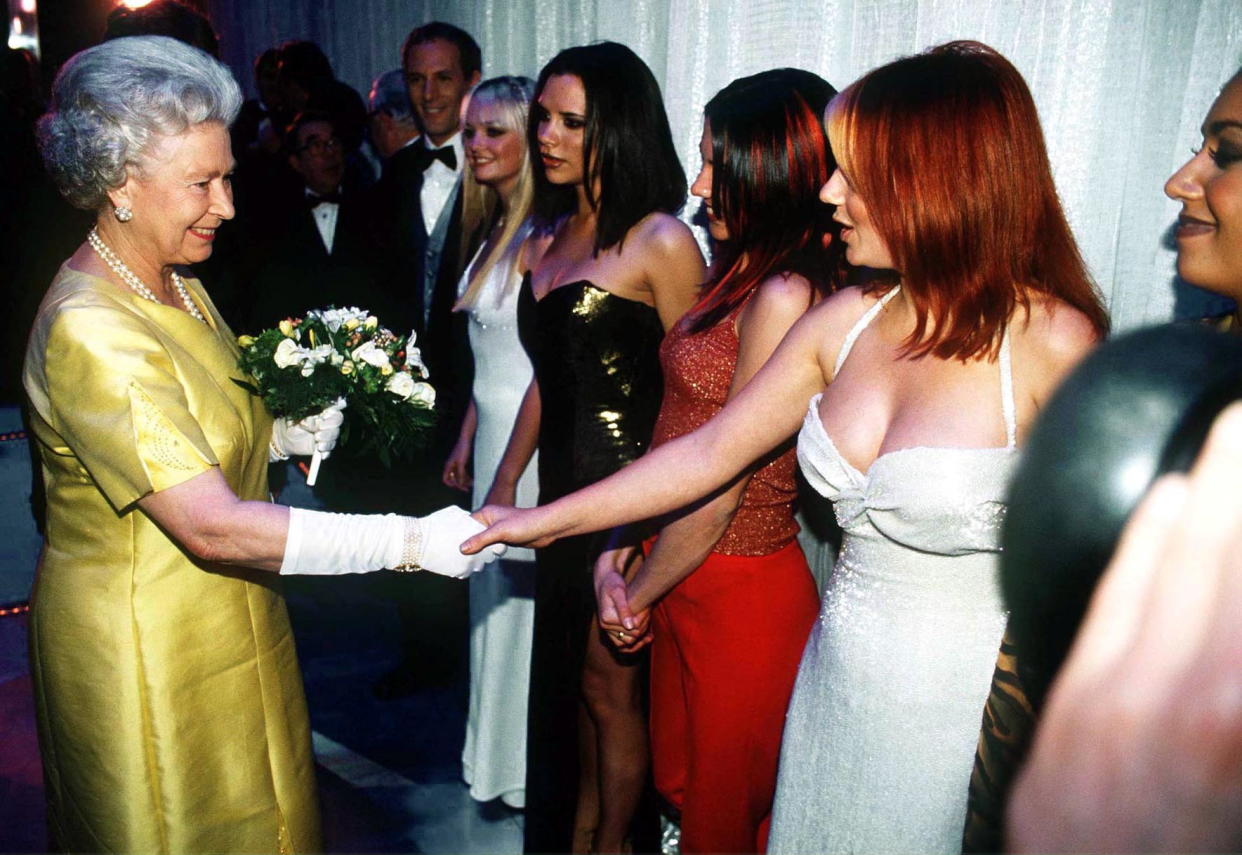 The queen shakes hands with the Spice Girls after a performance in 1997. (Tim Graham Picture Library / Getty Images)