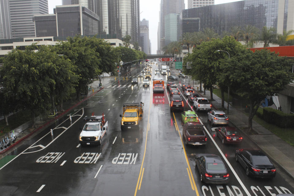 A storm brings a rainy morning commute through downtown Los Angeles, Wednesday, March 29, 2023. A cold low pressure system spinning off the coast of California sent bands of rain and snow across the state Wednesday, making travel difficult and adding to an epic mountain snowpack. (AP Photo/John Antczak)