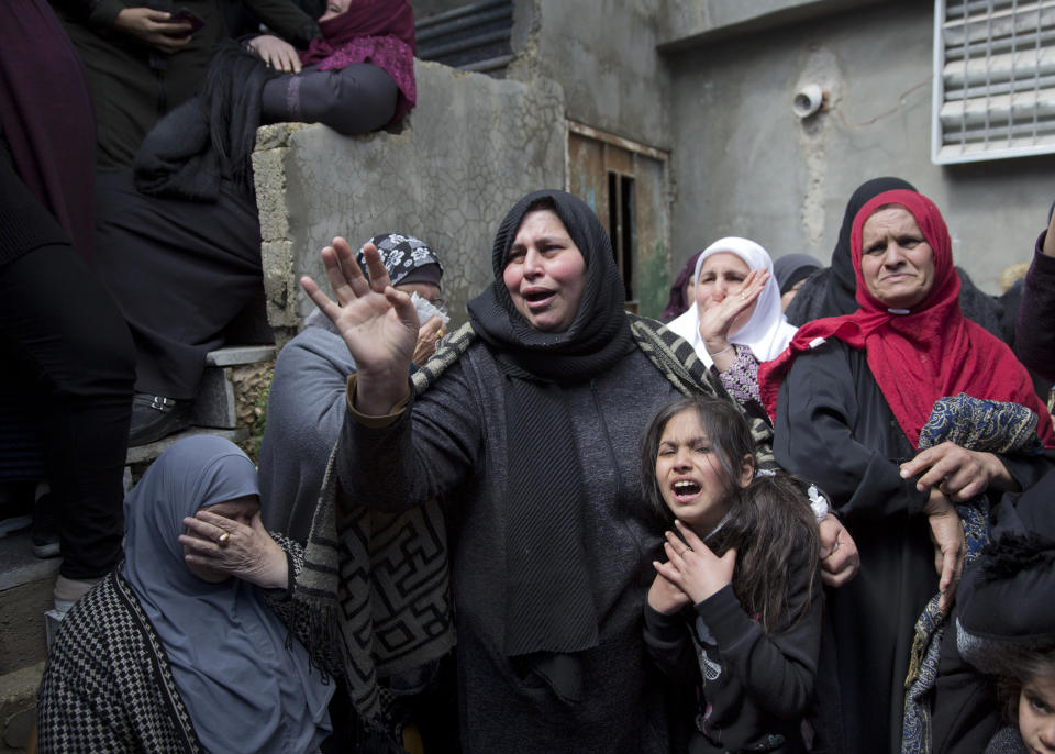 Samira Edwan, 40, left, mother, and Yusra, 10, sister, take a farewell look at the body of Mohammad Edwan, 23, who was shot and killed by Israeli troops, in the West Bank Refugee camp of Qalandia, near Ramallah, Tuesday, April 2, 2019. A West Bank medical official said Palestinian Mohammad Edwan was killed in clashes with Israeli forces during arrest raids north of Jerusalem. (AP Photo/Nasser Nasser)