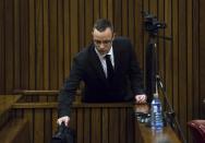 Oscar Pistorius puts his bag upon his arrival at a courtroom for his ongoing murder trial at the high court in Pretoria, South Africa, Tuesday, May 13, 2014. Pistorius is charged with the shooting death of his girlfriend Reeva Steenkamp on Valentine's Day in 2013. (AP Photo/Daniel Born, Pool)