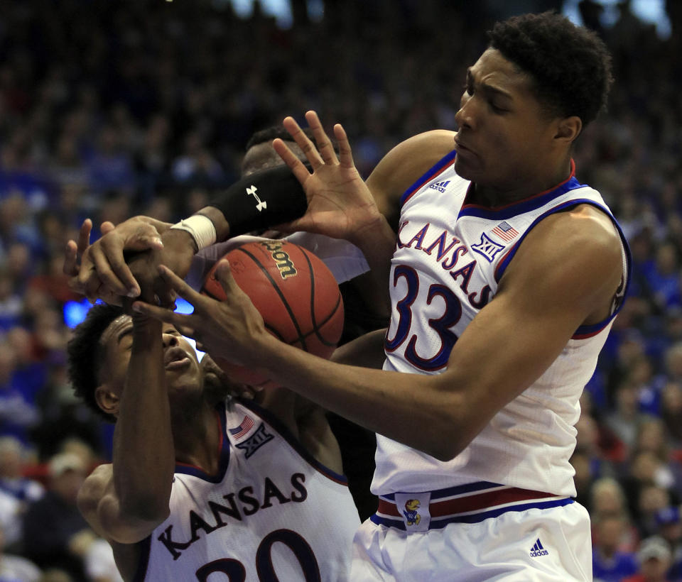 Kansas forward David McCormack (33) rebounds with guard Ochai Agbaji (30) during the second half of an NCAA college basketball game in Lawrence, Kan., Saturday, Feb. 2, 2019. Texas Tech center Norense Odiase, back, is boxed out on the play. Kansas defeated Texas Tech 79-63. (AP Photo/Orlin Wagner)