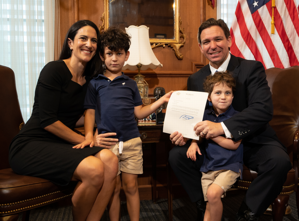 El gobernador Ron DeSantis posa con la recién nombrada jueza de la Corte Suprema de la Florida Meredith Sasso y sus hijos en su oficina el martes 23 de mayo de 2023.