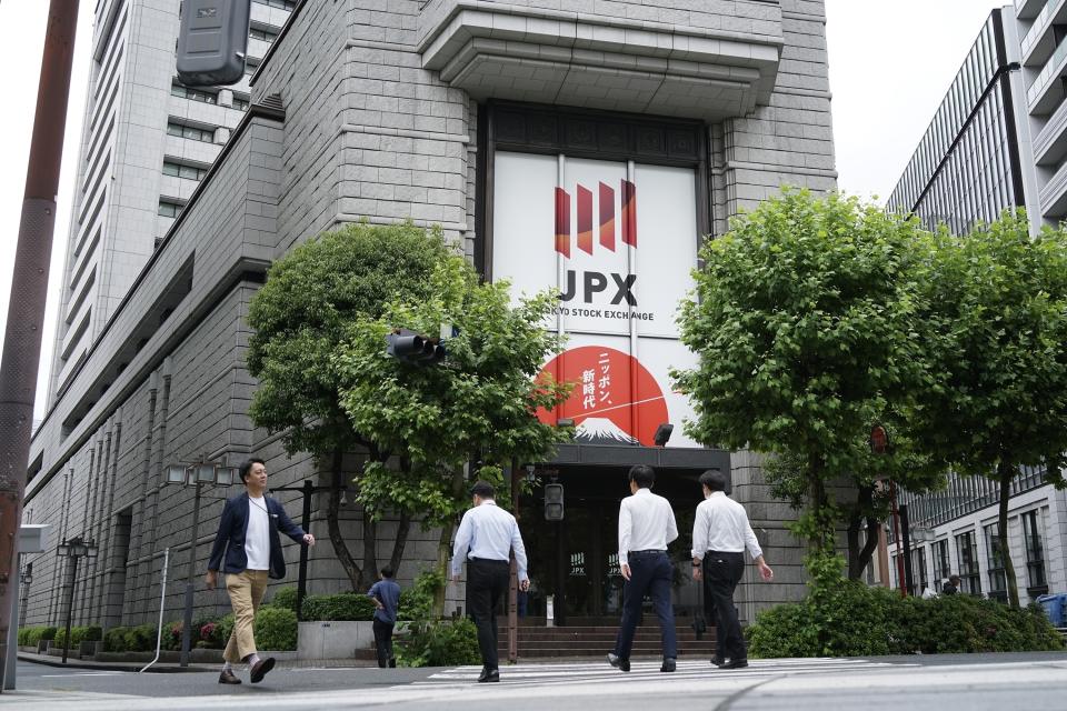 FILE - People walk in front of Tokyo Stock Exchange building in Tokyo, on May 28, 2024. (AP Photo/Eugene Hoshiko, File)