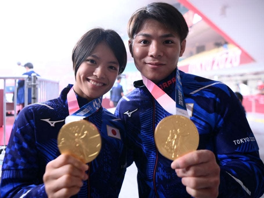 Uta Abe and Hifumi Abe hold their gold medals at the Tokyo Olympics