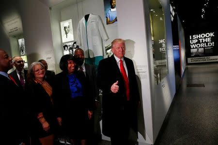 U.S. President Donald Trump (R) gives the thumb-up at the Dr. Ben Carson (2ndR) exhibit while visiting the National Museum of African American History and Culture in Washington, U.S., February 21, 2017. REUTERS/Jonathan Ernst