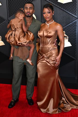 <p>ROBYN BECK/AFP via Getty</p> Hazel Monet Gaines (L), John Gaines (C) and US singer-songwriter Victoria Monét