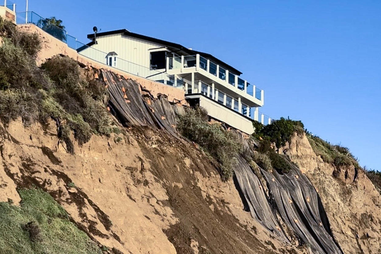 Tarps cover the bluff behind a home looking over Capistrano Beach in Dana Point, Calif. Several seaside neighborhoods are dealing landslides and concerns of coastal erosion following lates round of storms hitting the state. (NBC News)